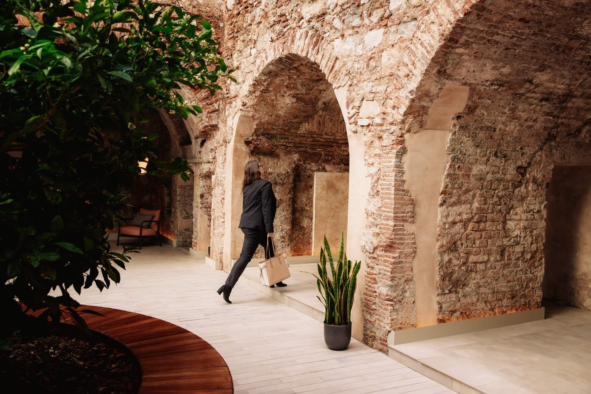 Xapo Bank employee walking under stone arches at the headquarters in Gibraltar.