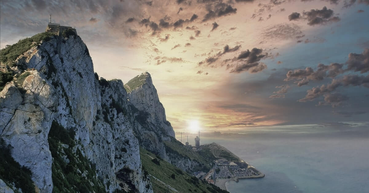 Landscape shot of Gibraltar Rock with the sun low on the horizon, providing context for Xapo Bank's location.